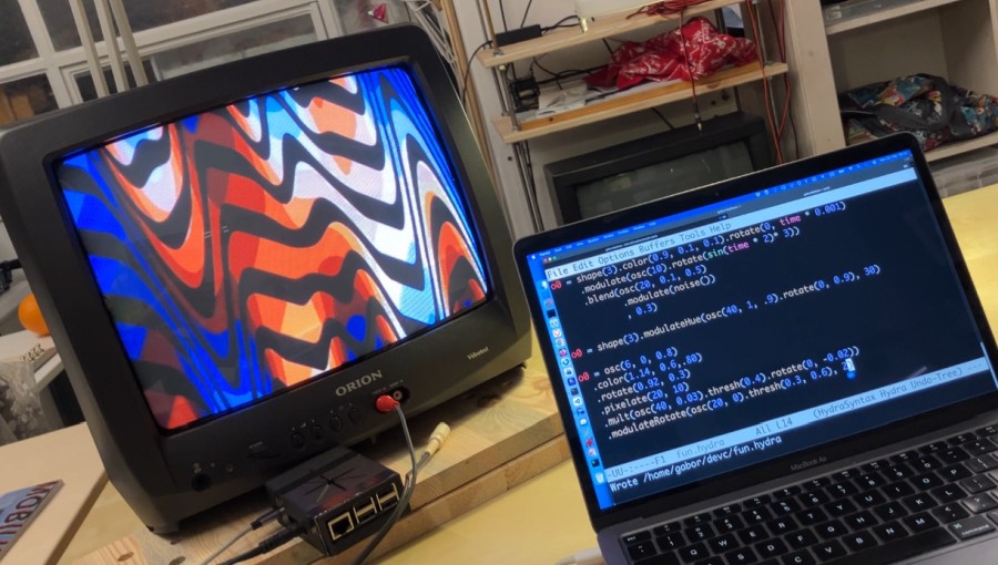 A CRT television showing a trippy visual, a Raspberry Pi, and a laptop
